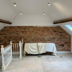 Exposed brick wall against fresh plaster