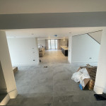 Open plan living space painted white with grey slate effect tiles